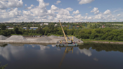 Aerial view large crane an excavator mounted on barge. Excavator on river for unloading and loading sand and rubble.