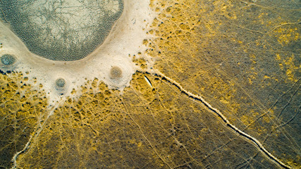 Aerial view of a small canoe next to a dried-up waterhole in Africa, Botswana, Okavango Delta in...