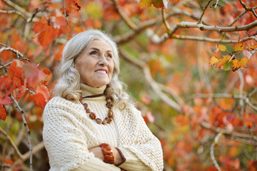 Portrait of happy senior woman in autumn park