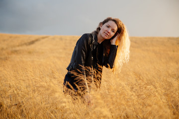 Blonde beautiful girl portrait in the golden field.