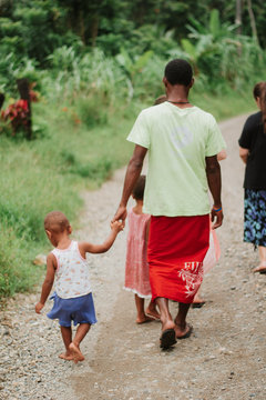 Fijian family walking home