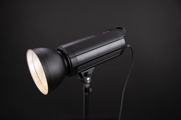 Head of studio flash strobe lamp light. Side view professional studio photography lighting close up on black background.