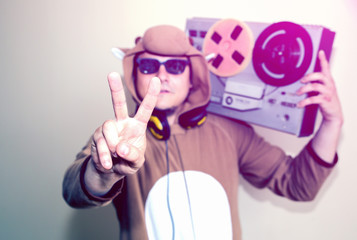 Man in cosplay costume of a cow with reel tape recorder. Guy in the animal pyjamas sleepwear. Funny...