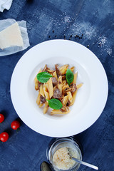 Top view Fresh Italian pasta penne with mushrooms, basil and veal. Concept of homemade food. Italian cuisine. Trafitional lunch food. Selective focus, Copy space