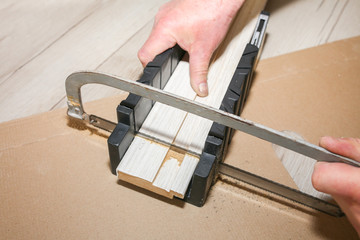 Man is installing the doors. Carpenter sawing wooden plank. Repair works. Maintenance in the...