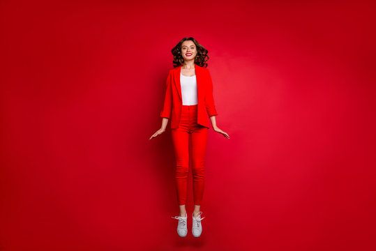 Full length photo of cute girl jumping looking isolated over red background