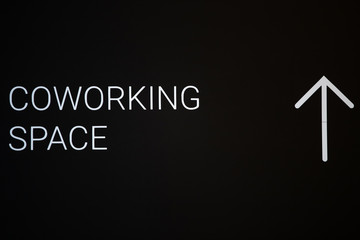 Black coworking space signboard on the office wall with copy space