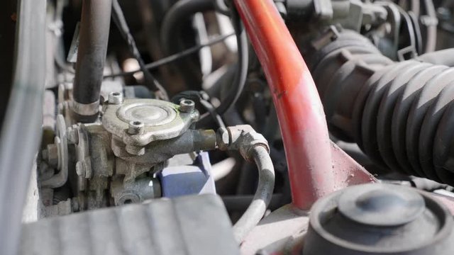 Close-up of the gas plant gearbox in the hood of red car. 4K footage.Transformation to LPG gas of petrol car. Detail of the LPG filter. 4K footage.