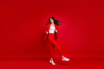 Full size photo of fancy girl touching her modern jacket turning around looking isolated over red...