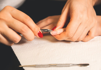 Woman is making a manicure. Salon procedures at home. Beautiful hands and nails.