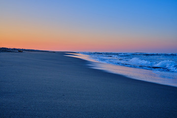Sunrise over the ocean waves, spray.