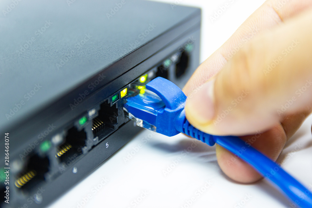 Poster hand of man holding the blue network cables connect port switch on white table concept internet netw