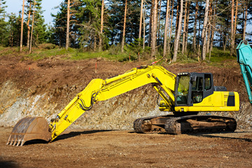 Close-up of yellow excavator construction machine at the construction site.