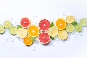 Foto op Plexiglas Colorful fruits backround. .citrus slices,orange, lemon, lime, and grapefruit with ice and mint. white background. Top view © Miguel Tamayo 