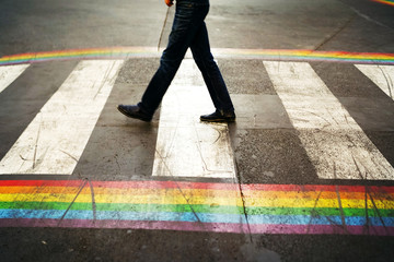 Road marking of pedestrian crossing and rainbow flag in Paris. Sex discrimination concept....