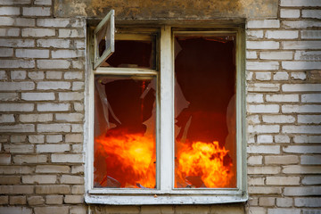 Picture of brick house with with fire in window.