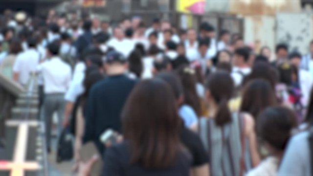 UMEDA, OSAKA, JAPAN - CIRCA JULY 2019 : Blurred view of crowd of people walking down the street in busy rush hour. Many commuter walking near Osaka train station after work. Shot in early evening.