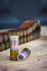HUNTING CARTRIDGES AND BELT ON WOODEN TABLE. HUNTING PHOTOGRAPHY