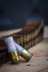 HUNTING CARTRIDGES AND BELT ON WOODEN TABLE. HUNTING PHOTOGRAPHY