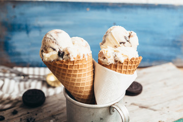 studio shoot of delicious ice cream in cone on blue wooden background