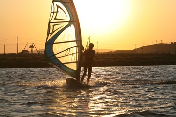 Windsurfer rides at sunset in the Black sea, Russia.