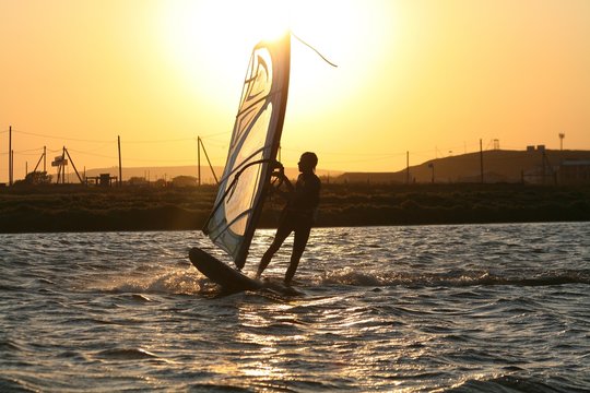 Windsurfer rides at sunset in the Black sea, Russia.