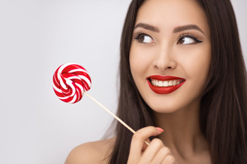 Fashion Portrait of Asian Woman with Lollipop in Studio