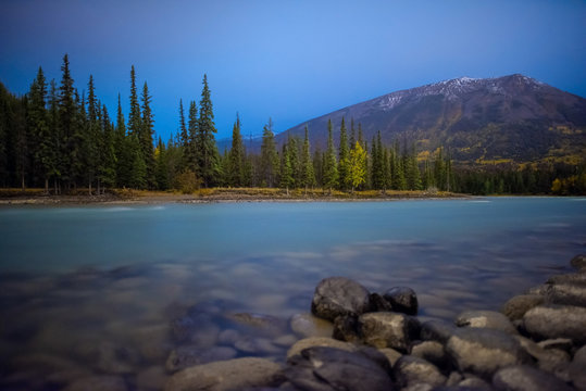 Paisaje nocturno del lago Louis en Jasper Alberta Canada, lago que se encuentra rodeado por bosque pinos y monta&ntilde;as, un lago con agua azul turquesa y rocas. uesa 