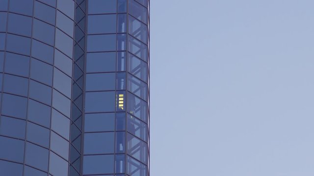 Glass Elevator Going Up the Glazed Facade of Skyscraper. Glass Curtain Facade Wall Background.