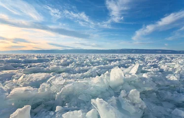 Fotobehang Winter landscape of the frozen Baikal Lake. Fields of ice hummocks with heaps of large blocks of ice on the Small Strait at sunset. Cold natural background © Katvic