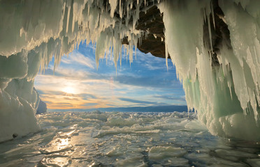 Unusual winter landscape of the frozen Baikal Lake. Beautiful view on sunset from an ice grotto...