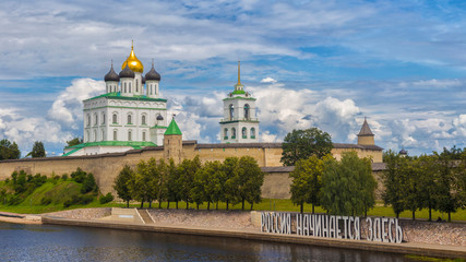 Kremlin in Pskov, Russia. Ancient fortress. Golden dome of Trinity Church. On the bank of the river the Great inscription in Russian "Russia begins here"