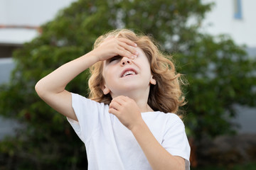 Blond child covering his eyes