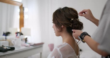 Hair stylist makes hair for bride in beauty salon