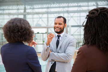 Professional business people talking. Smiling multiethnic male and female business colleagues standing together and talking. Teamwork concept