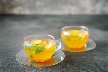 Two glass cups of fruit tea on dark background