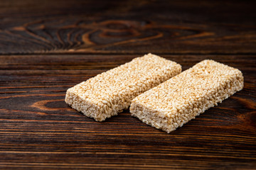 Sesame kozinaki on dark wooden background.