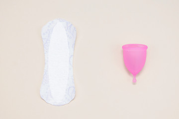 Menstrual cup and menstrual pad on a light background, flat lay.Zero waste concept.Alternative plastic.