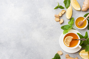White Cup with natural herbal tea ginger lemon mint and honey. Gray background Copy space.