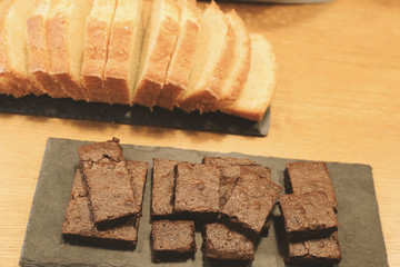 Homemade chocolate brownies and sliced buttercake on wooden table, top view, toned image.