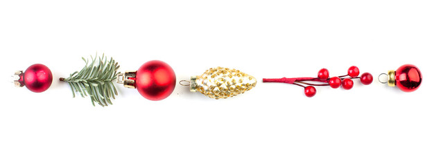 Christmas composition in row. Red holly berries, green fir branch and baubles on white background