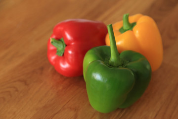 Composition with three color - red, green, yellow fresh sweet pepper or bell pepper on wooden background.