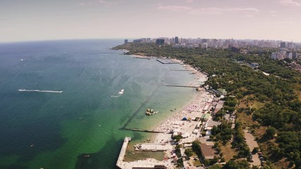 Aerial shot of a sea coast line during summer sunny day, boats are passing by