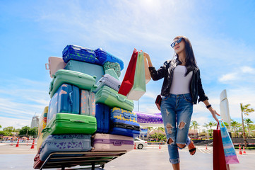 woman enjoy shopping funny in outdoor, cheerfully at shopping mall yard, hand up to the air at most happy enjoyment, Luggages and trolley Model in along happiness