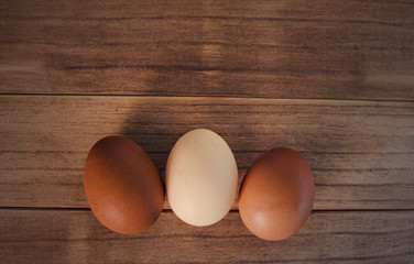 Top view of three eggs on a wooden background. Copy space