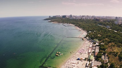 Aerial shot of a sea coast line during summer sunny day, boats are passing by