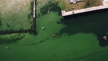Top down aerial view of a group of paddle boarders floating in a sea