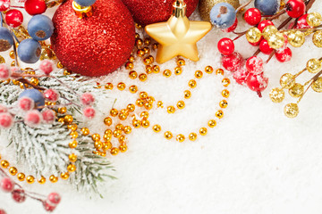 Bright Christmas composition with red baubles, holly berries, Xmas tree branch and golden garland...