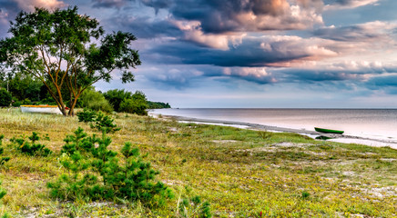 Fototapeta na wymiar Coastal landscape with small fishing boat at sandy beach of the Baltic Sea