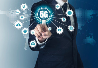 A businessman in suit touch the screen with 5G hologram icon